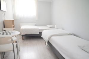 Pokój z 2 łóżkami, stołem i oknem w obiekcie Willa Na Nehringa w Poznaniu