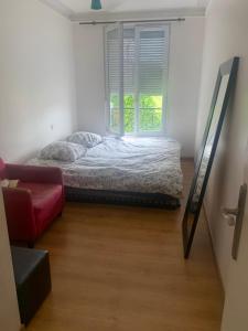 a bed in a room with a window and a couch at One Bedroom Appartement - Paris in Paris