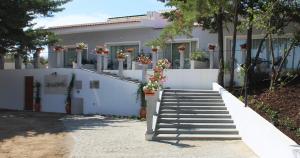 a white house with stairs and potted plants at Hotel Campo do Rosmaninho in Castelo Branco