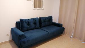 - un canapé bleu dans l'angle de la chambre dans l'établissement Apartments Villa Katija, à Drvenik