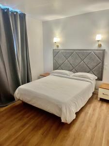 a bedroom with a large bed with a gray headboard at Hotel Aurelia in Les Arcs sur Argens