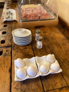 a wooden table with eggs and plates on it at Hotel Binelli in Pinzolo