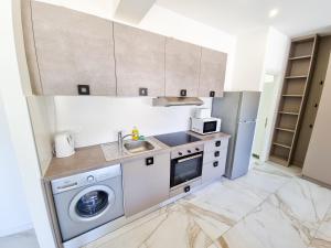 una cocina con lavadora y fregadero en Happy Homes Paradise, en Lárnaca