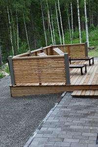 um deque de madeira com um banco e um banco em Himos Villa Nummenranta 1 em Jämsä