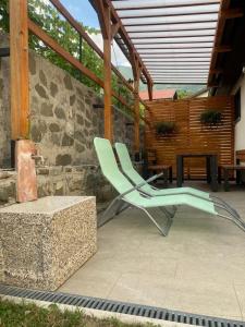 a pair of green chairs sitting on a patio at apartma MAKS in Podbela