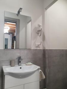 y baño con lavabo blanco y espejo. en 5 Terre Station Rooms en La Spezia