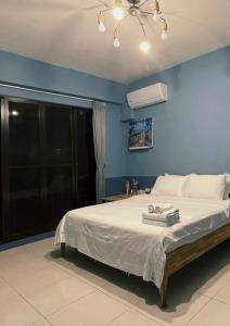 ein blaues Schlafzimmer mit einem Bett mit Handtüchern darauf in der Unterkunft Donggang Homestay-Dongfan in Donggang + 25 Fotos