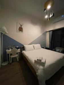 ein Schlafzimmer mit einem Bett und einem Tisch mit einem Stuhl in der Unterkunft Donggang Homestay-Dongfan in Donggang