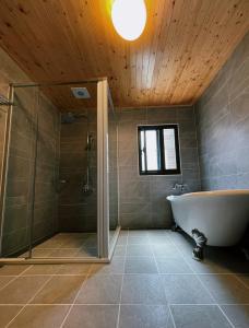 ein Badezimmer mit Badewanne und Glasdusche in der Unterkunft Donggang Homestay-Dongfan in Donggang