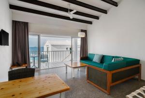 uma sala de estar com um sofá verde e uma mesa em AluaSun Far Menorca em S'Algar