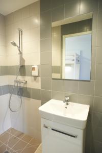 uma casa de banho com um lavatório e um chuveiro com um espelho. em Logis Hotel Chateaubriand em Nantes