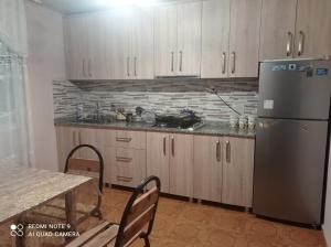 a kitchen with a stainless steel refrigerator and a table at Bata Apartment in Sarpi