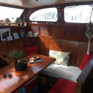 a room with a table and a bench in a boat at Eco-responsible stay on the historical sailing boat of the Gaiarta Project - come and stay with our crew and get the whole boat experience in Saint-Cyprien