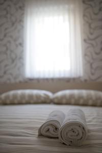 two towels laying on a bed in front of a window at Villa Novak in Okrug Donji