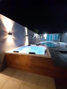 eine große Badewanne, die nachts neben einem Gebäude sitzt in der Unterkunft a termas voy in Termas de Río Hondo