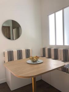 een eetkamer met een tafel en een spiegel bij Bel appartement, offrant calme et luminosité, proche Côte des Basques in Biarritz