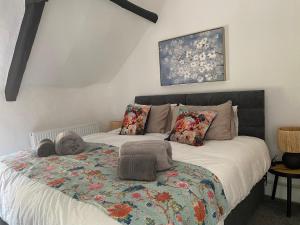 Un dormitorio con una cama grande con una manta. en The Nook- A Rustic Cottage in a Beautiful Village. en Draycott