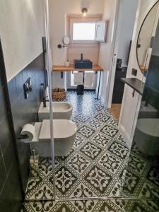 ein Badezimmer mit 2 WCs, einem Waschbecken und einem Tisch in der Unterkunft Affittacamere Faber in Tempio Pausania