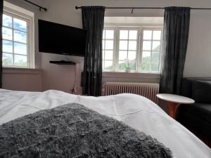 1 dormitorio con 1 cama y TV de pantalla plana en Krebshuset / Kelz0rdk, en Sorø