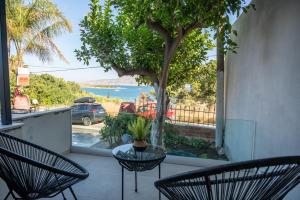 a patio with two chairs and a table and a tree at Eleftherias Suites - Near Beach Apartments in Marathi