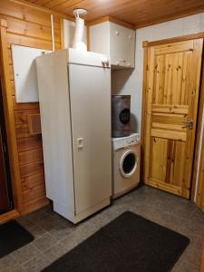 eine kleine Küche mit einem Kühlschrank und einer Waschmaschine in der Unterkunft Kärpänrinne A in Syöte