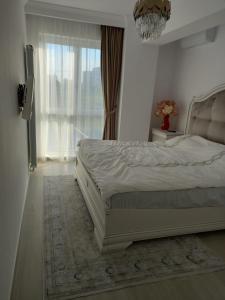 a bedroom with a bed with a chandelier and a window at Campus in Constanţa