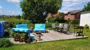 un patio con 2 sillas azules, una mesa y sillas en Atlantis B&B, en Łeba