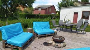 un patio con sillas azules, una mesa y una parrilla en Atlantis B&B, en Łeba