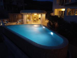 ein großer Swimmingpool in der Nacht mit einem Haus in der Unterkunft Villa Franka with swimming pool in Bol