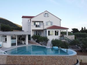 a villa with a swimming pool in front of a house at Villa Franka with swimming pool in Bol
