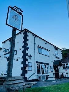 a white building with a sign in front of it at The Yew tree at Longhope in Longhope