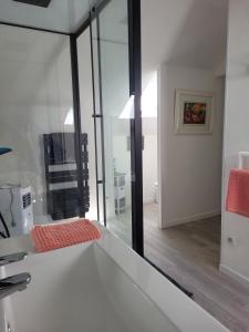 a room with glass walls and a room with a table at La maison d'Hera in Saint-Yrieix-la-Perche