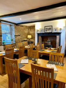 a restaurant with wooden tables and chairs and a fireplace at The Yew tree at Longhope in Longhope