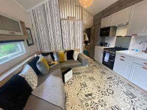 a living room with a couch and a kitchen at P76 - Riverside Family Pod with Hot Tub in Bethesda