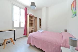 a bedroom with a pink bed and a chair at COMME A LA MAISON in Espéraza