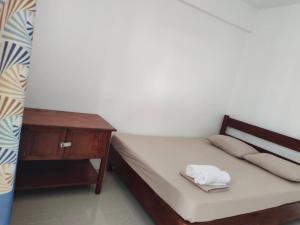 1 dormitorio con 1 cama con mesita de noche y toallas en Victoria Beach House, en San Vicente