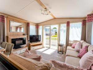 a living room with a couch and a television at Pass the Keys Delightful 2 bedroom caravan with parking in Wimborne Minster