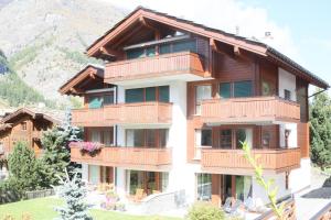 un bâtiment avec balcon et montagne en arrière-plan dans l'établissement Zermatt La Vallée, à Zermatt