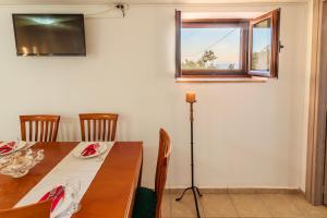 a dining room with a table and a window at Mani Summer Escape - Spacious Home, Fully equipped in Levktron