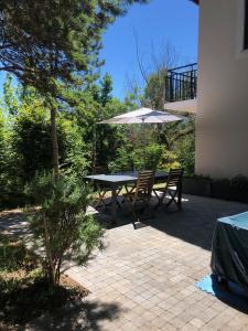 eine Terrasse mit einem Tisch und einem Sonnenschirm in der Unterkunft Villa Haute Savoie in Chessenaz