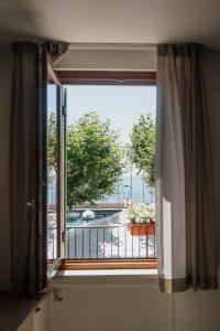 ein Fenster mit Blick auf einen Balkon in der Unterkunft Welcome Traveller LA CASA DEGLI ACQUERELLI in Garda