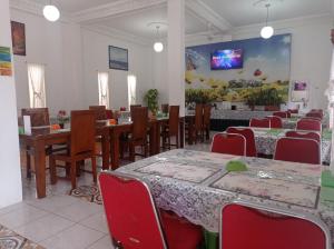 jadalnia ze stołami i krzesłami oraz telewizorem w obiekcie HOTEL NAYORA PRABUMULIH w mieście Perabumulih