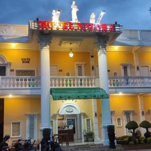 - un grand bâtiment avec un balcon en haut dans l'établissement HOTEL NAYORA PRABUMULIH, à Perabumulih