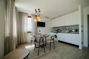a kitchen and dining room with a table and chairs at Welcome Traveller LA CASA DEGLI ACQUERELLI in Garda