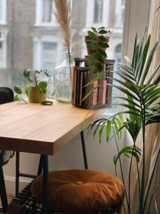 a wooden table with plants on it next to a window at Stylish 1 bed Garden Flat in the Heart of East London in London