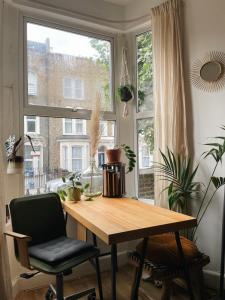 a table and two chairs in a room with a window at Stylish 1 bed Garden Flat in the Heart of East London in London