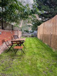 a picnic table and two chairs in a yard at Stylish 1 bed Garden Flat in the Heart of East London in London