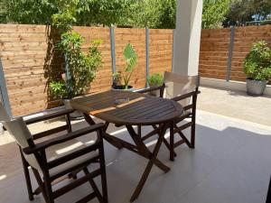 una mesa de madera y 2 sillas en el patio en Andromahi Apartments & Suite, en Laganas