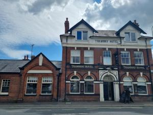 a man walking in front of a brick building at Tramway hotel in Pakefield