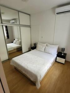 a bedroom with a large white bed and a mirror at Apartment Dora in Dubrovnik